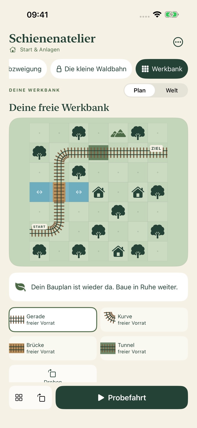 Bauplan in Schienenatelier mit Gleisstrecke, Landschaft und Werkzeugen zum Weiterbauen